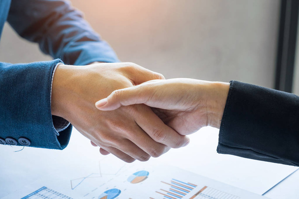 Dos hombres de negocios dando la mano durante una reunión en la oficina
 - Foto, Imagen