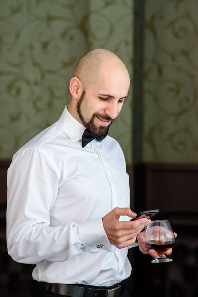 A bald man speaks on the phone in the restaurant. - Photo, image