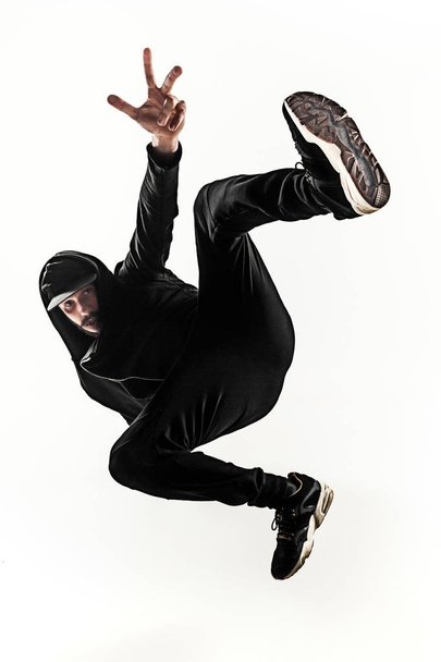 The silhouette of one hip hop male break dancer dancing on white background - Фото, изображение