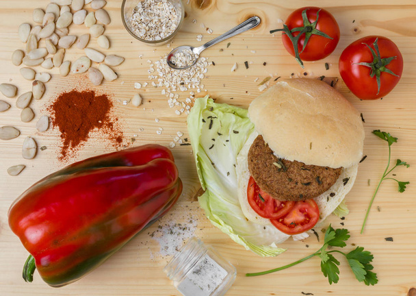 Homemade veg burger with ingredients, on a light wooden background.  - Фото, изображение