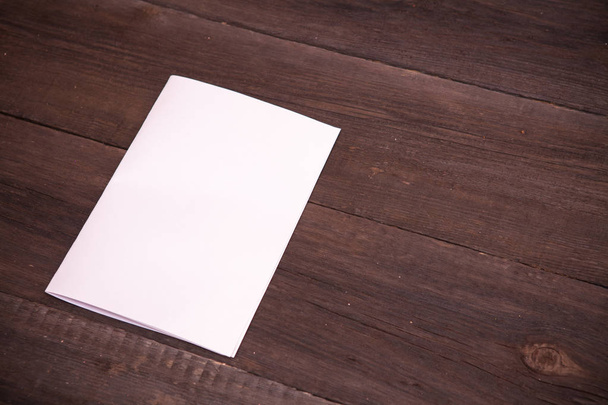 sheet of paper folded in half on a wooden background - Foto, imagen
