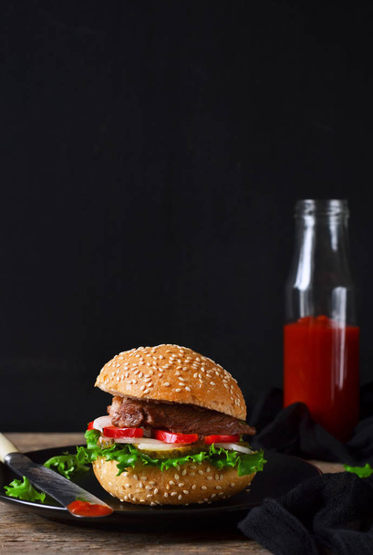hausgemachter Burger mit Rindfleisch, Salat und Tomatensauce  - Foto, Bild