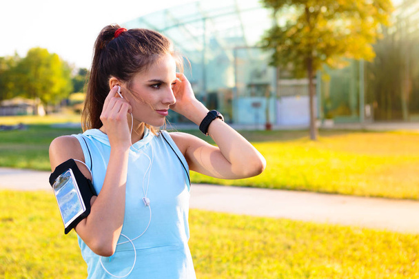 Sportovní žena poslechu hudby pomocí sluchátek - Fotografie, Obrázek