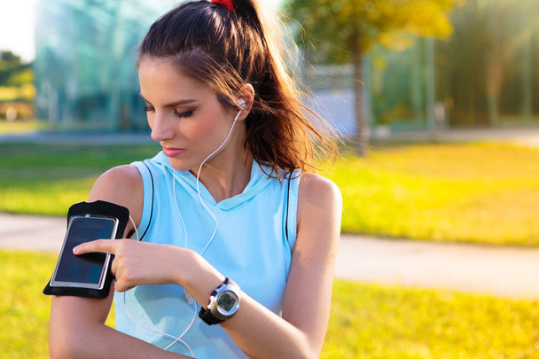 Sporty Woman listening to music with earphones - Photo, Image