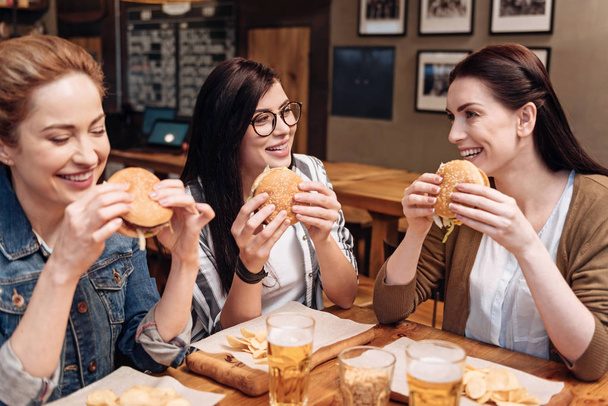Satisfied females eating fresh burgers - Photo, Image