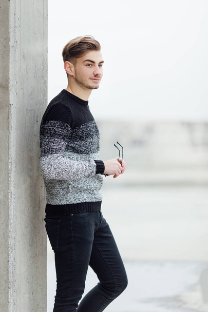 Fashionable man standing near wall with blur background - Fotó, kép