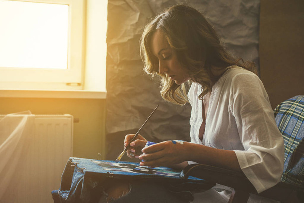Artista pinta quadro em tecido com tintas acrílicas em sua oficina
 - Foto, Imagem