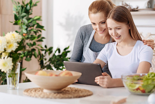 Cheerful mother and her daughter using tablet - Foto, Imagen