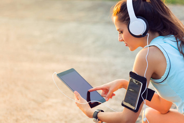 Mulher ouvindo música com fones de ouvido de seu Tablet
 - Foto, Imagem