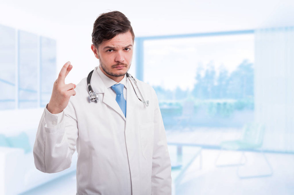 Vakava lääkäri tai lääkäri, jolla on sormet ristissä
 - Valokuva, kuva