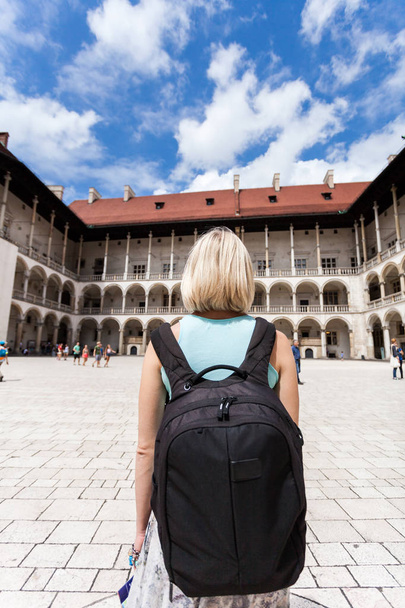 Female traveler on the background of Arcades in Wawel Castle in Cracow. - Photo, Image
