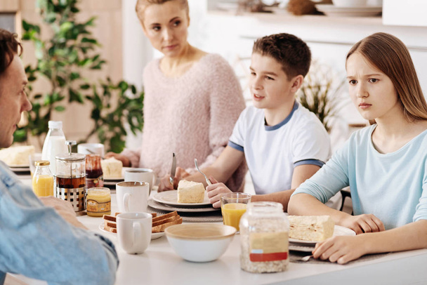 Confused girl having breakfast with her family - Foto, Imagem