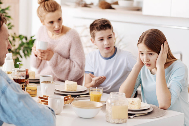 Depressed girl having breakfast with her family - Foto, imagen