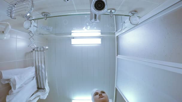 Une fille en robe de chambre blanche dans une salle de douche
. - Séquence, vidéo