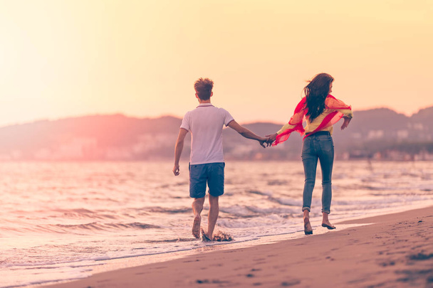 Couple on beautiful beach at sunset - 写真・画像