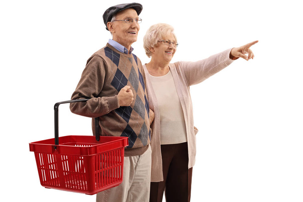 man holding shopping basket with woman pointing - Foto, Imagen