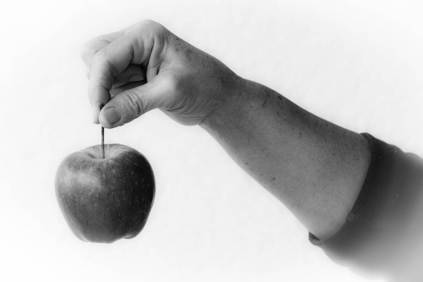 Apple opknoping van een vrouw hand - Foto, afbeelding