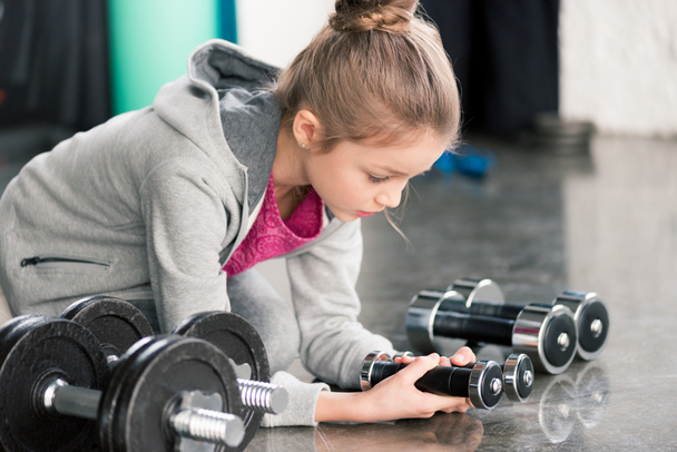 Lány gyakorlása súlyzókkal  - Fotó, kép