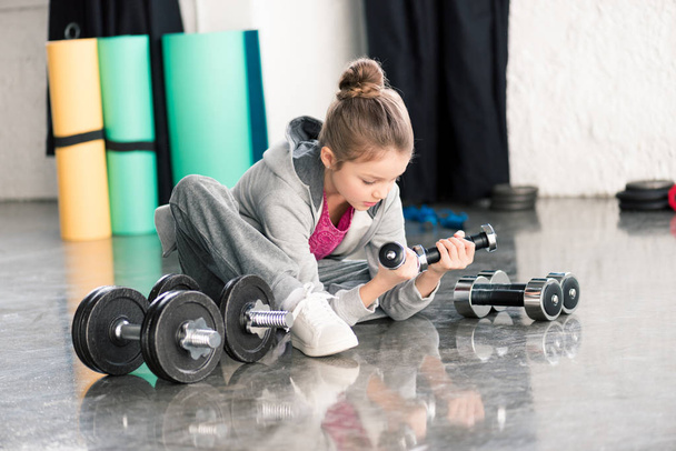 Girl exercising with dumbbells  - Foto, afbeelding