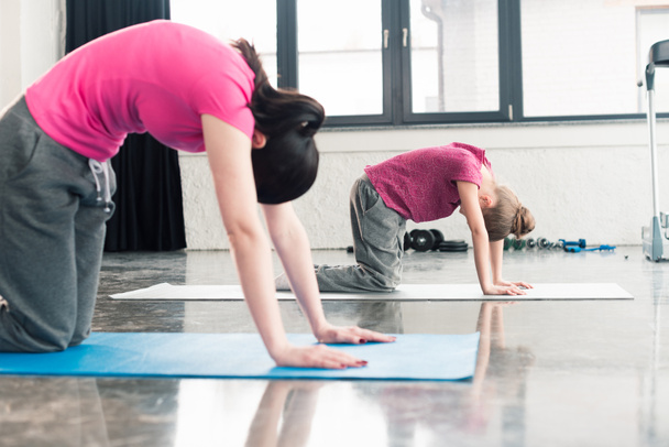 mother and daughter practicing yoga - Photo, Image