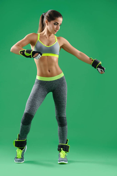 Beautiful sportswoman posing on green background - Fotografie, Obrázek
