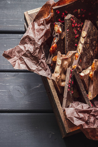 Разнообразие шоколадных батончиков в деревянной коробке
 - Фото, изображение