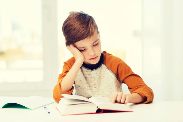 student boy reading book or textbook at home - Valokuva, kuva