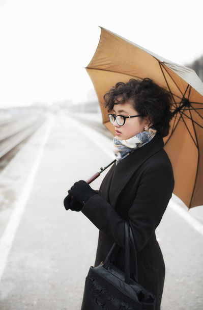 Meisje bedrijf paraplu op station - Foto, afbeelding