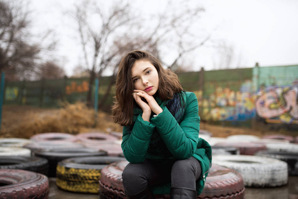 Teen girl sitting on tyres - Zdjęcie, obraz