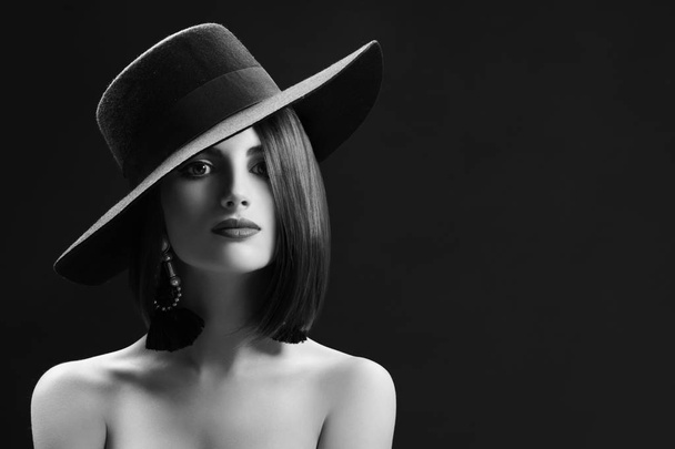 Ελκυστική γυναίκα που φοράει ένα καπέλο που παρουσιάζουν σε μαύρο φόντο - Φωτογραφία, εικόνα