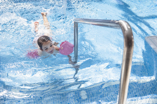 Menina desfrutando de piscina dentro de casa
 - Foto, Imagem