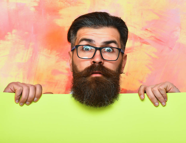bearded man with surprised face in glasses on colorful background - 写真・画像