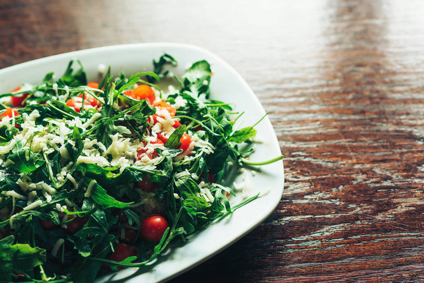 Taze salata domates, mutfak masasında ruccola ile. - Fotoğraf, Görsel