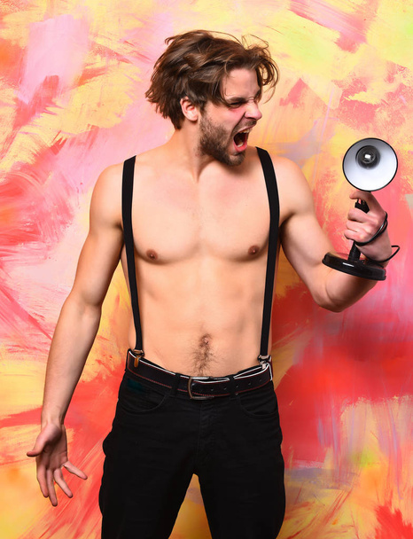 Caucasian bearded macho man in pants with suspenders holding lamp - Foto, afbeelding