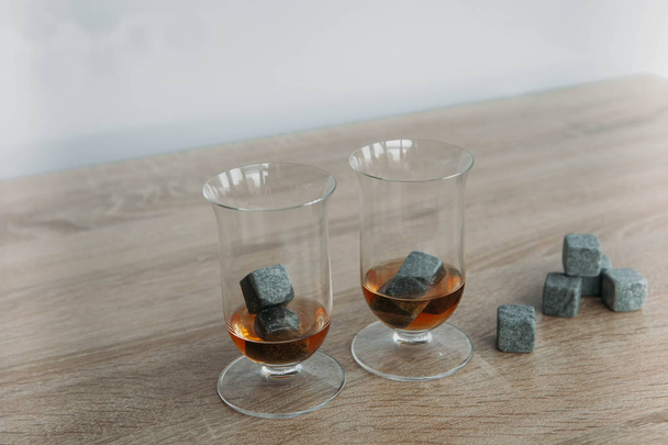 Stones for cooling whiskey and glases tulup on light wooden background - Foto, immagini