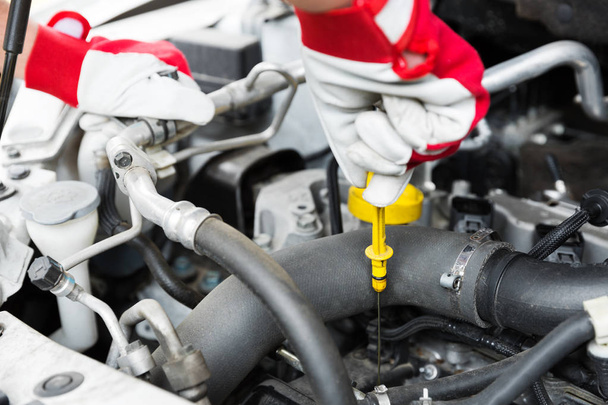 serviço de manutenção automóvel - verificação mecânica do nível de óleo do motor
 - Foto, Imagem