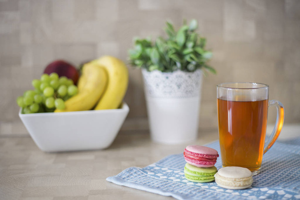 Still life with a cup of tea and macaroons on the table - Photo, Image