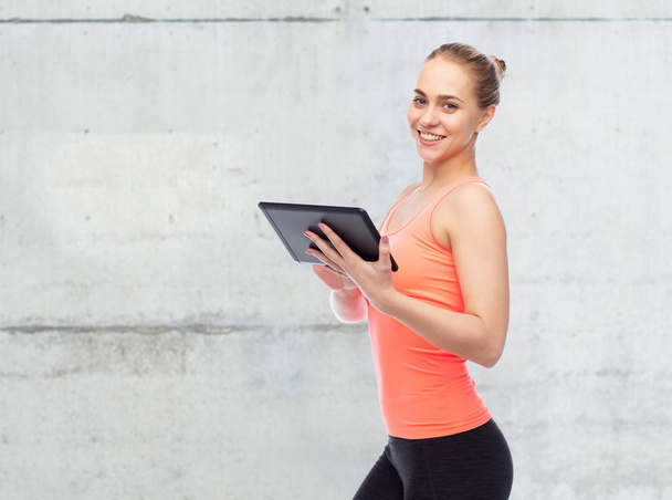 happy smiling sportive young woman with tablet pc - Foto, afbeelding
