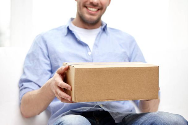 happy man with cardboard box or parcels at home - 写真・画像