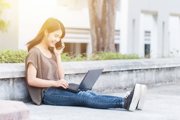 Asian Cute nastolatka kobiet w Uniwersytecie za pomocą smartfona i laptop nowoczesny styl życia. - Zdjęcie, obraz