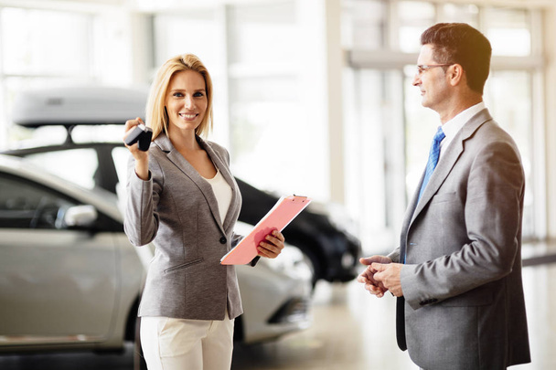 Saleswoman giving key of car - Фото, зображення