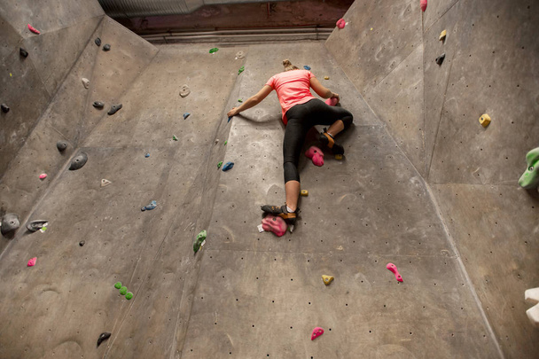 young woman exercising at indoor climbing gym - Foto, imagen