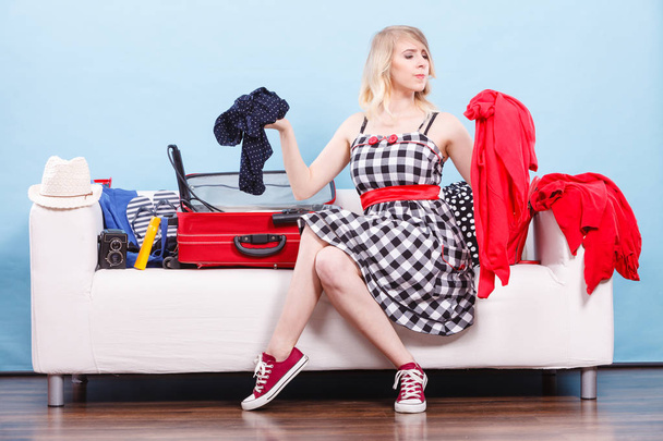 Woman choosing things to pack into suitcase - Фото, изображение