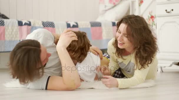 Young family having fun at the bedroom floor. - Felvétel, videó
