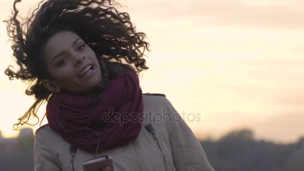 Young attractive woman having fun, listening to beloved singer music album - Filmagem, Vídeo