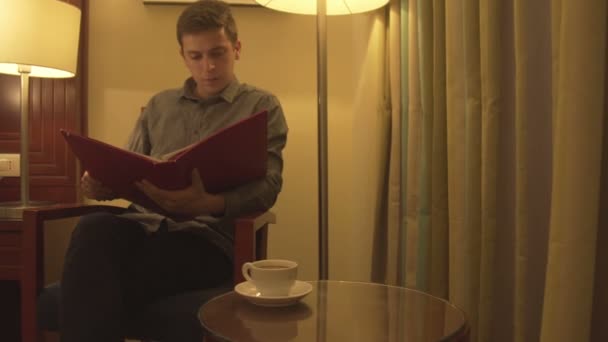 Mladý muž se snaží relaxovat čtení časopisu - Záběry, video