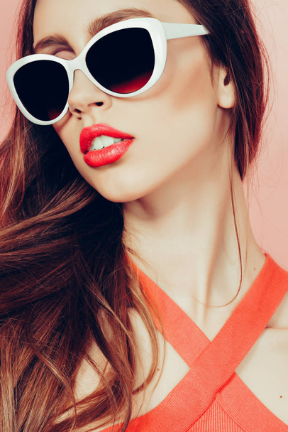 portrait of young beautiful slim woman in sexy dress with sensual lips in studio wearing sunglasses smiling and posing - Fotoğraf, Görsel