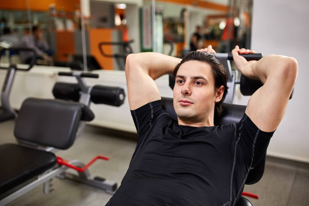 Fitness and Sport. Athletic man doing exercises with arm in gym - Fotoğraf, Görsel