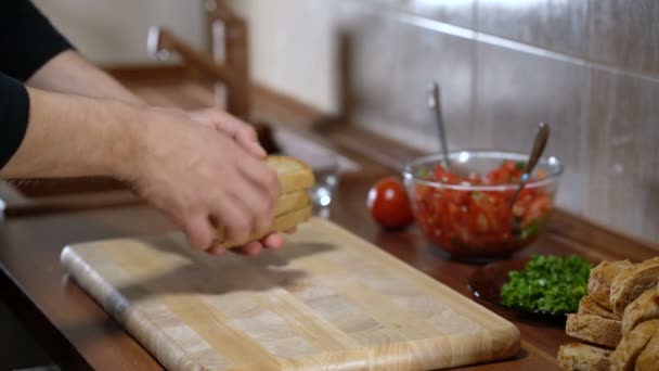 A man arranges bread for cooking bruschetta - Video, Çekim