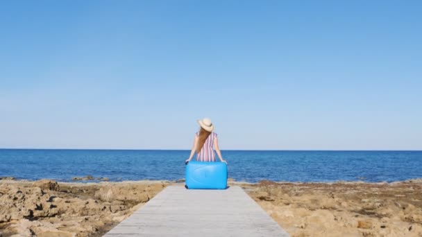 Viaggiatore donna seduta sulla sua valigia sulla spiaggia
 - Filmati, video